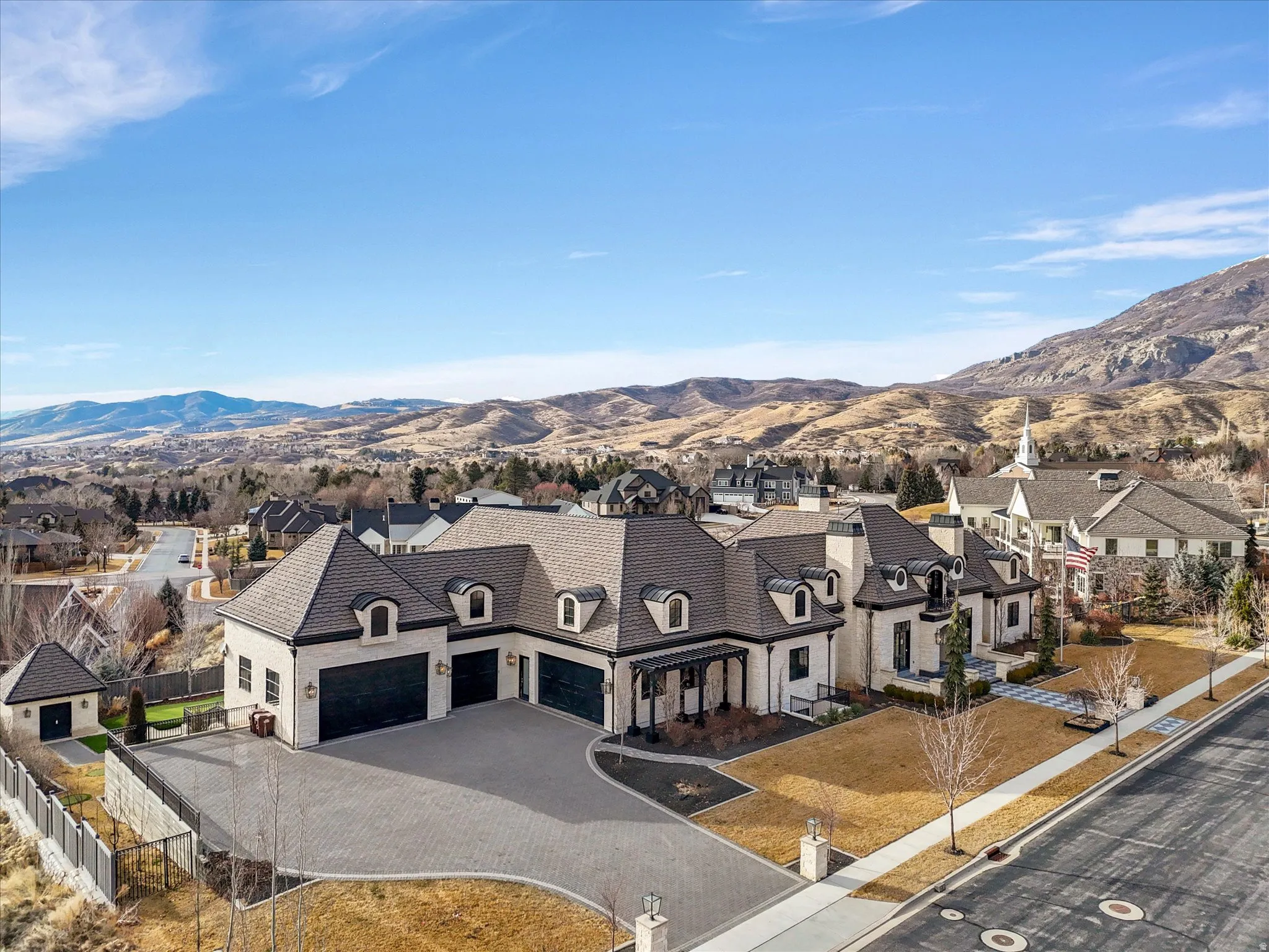 View of front facade featuring a mountain view, driveway, a residential view, and a garage