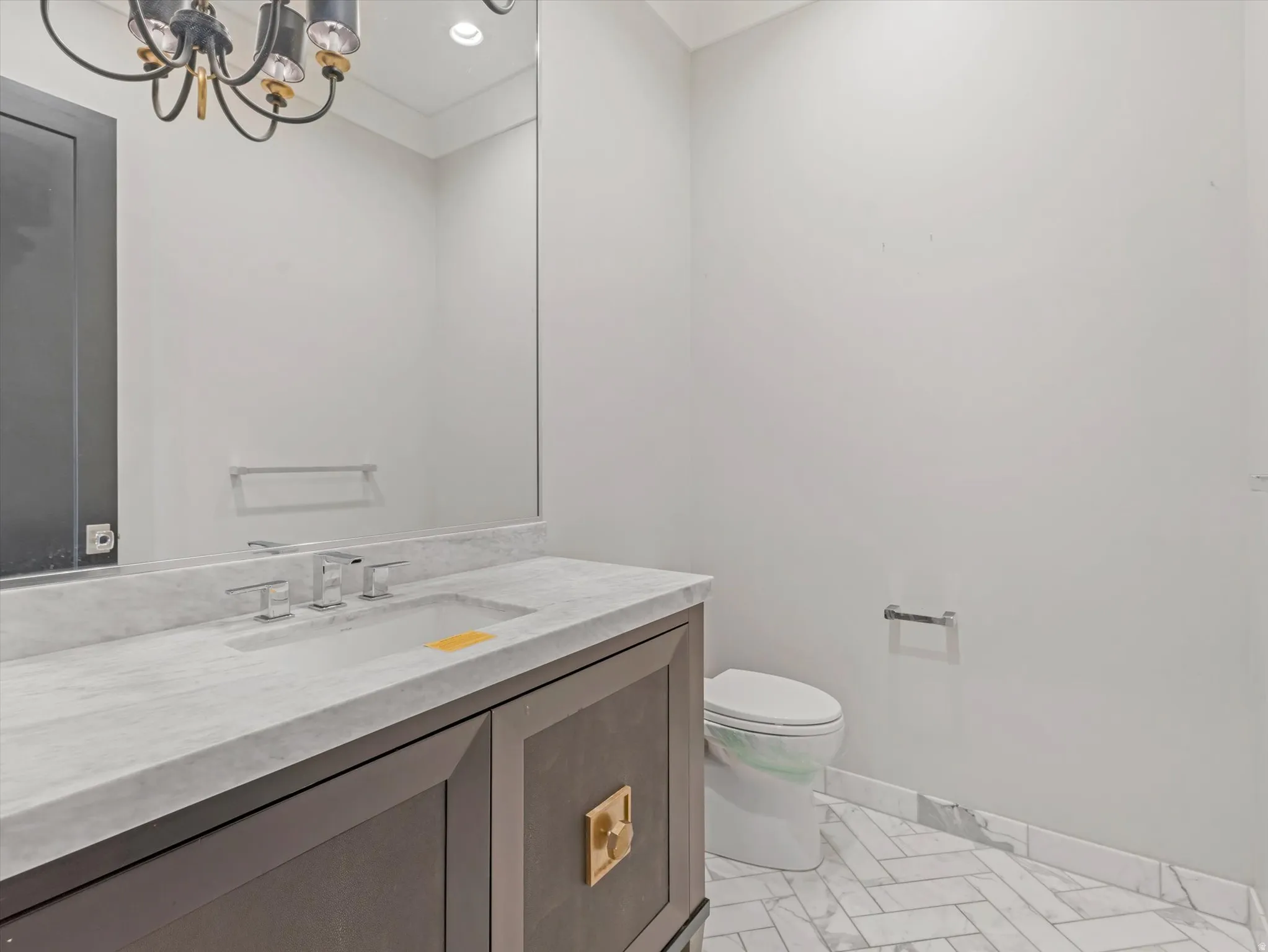 Half bathroom featuring vanity and a chandelier