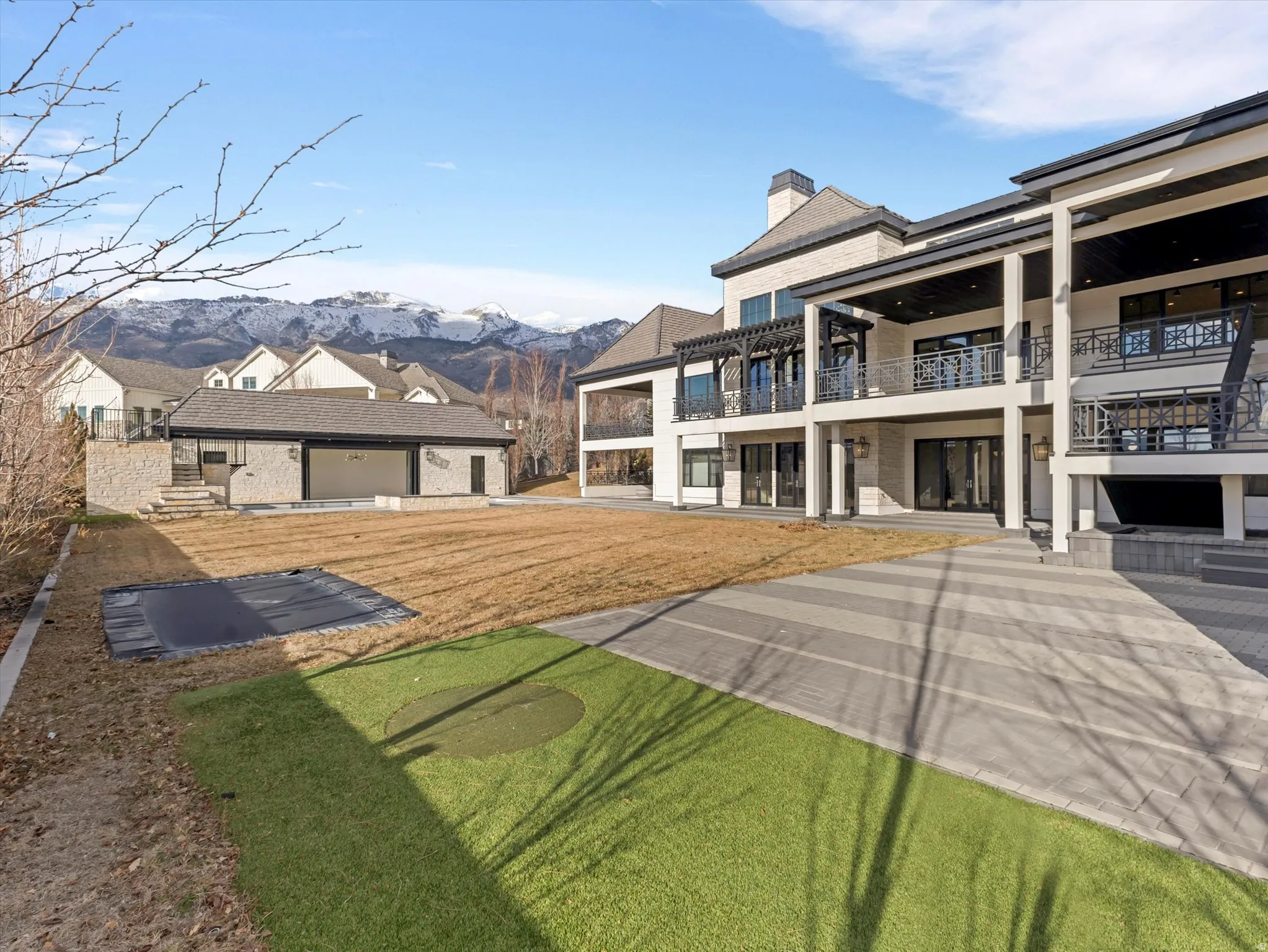 View of grassy yard with a balcony, a patio area, and a mountain view