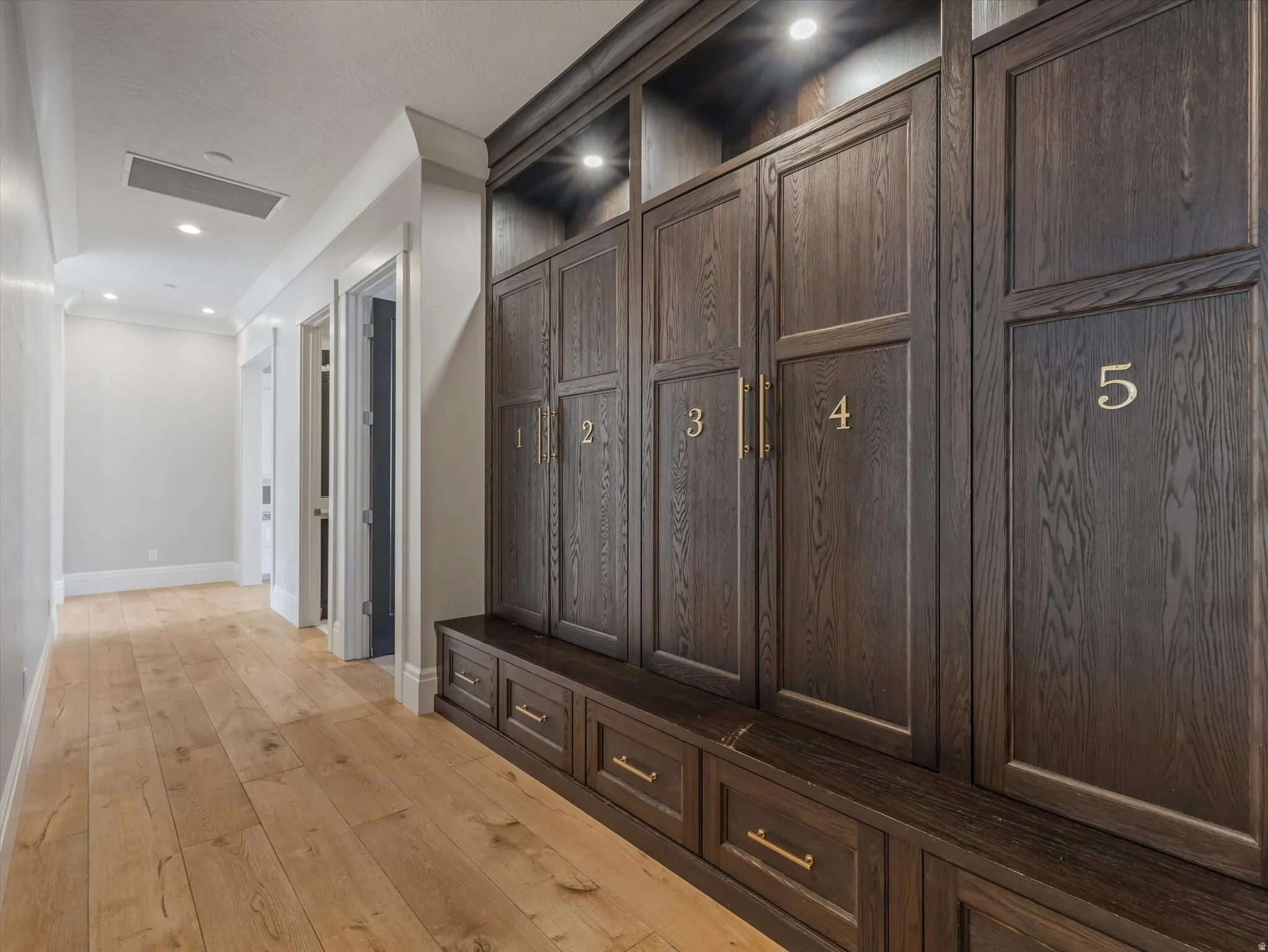 Mudroom from the garage with light wood-style flooring and recessed lighting