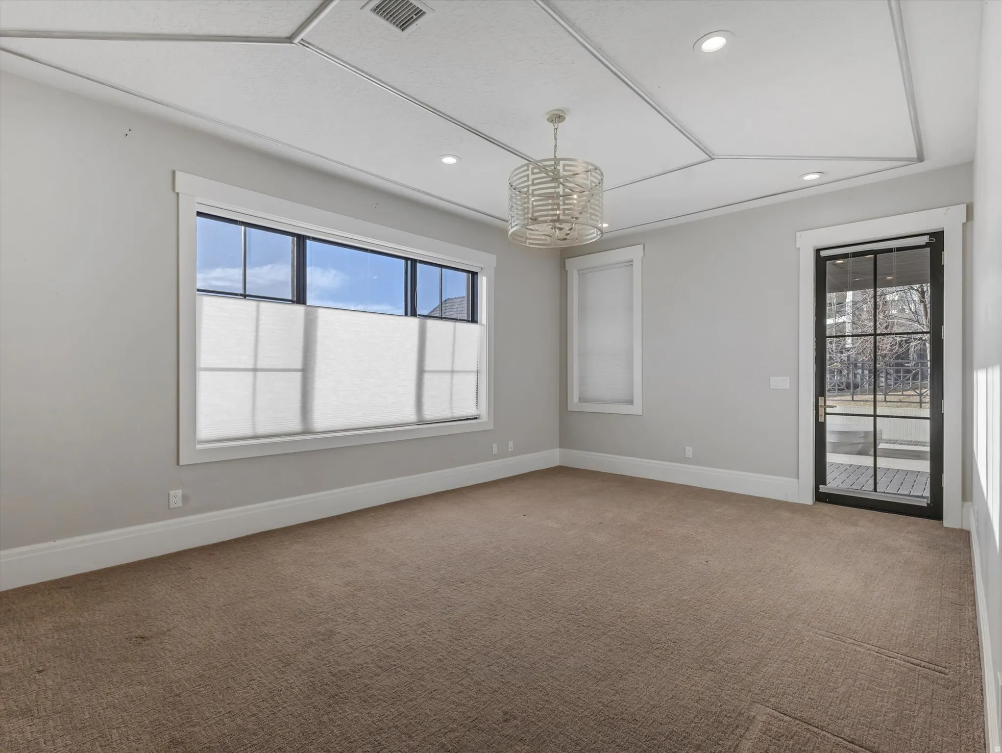 Bedroom featuring light carpet and hanging lights