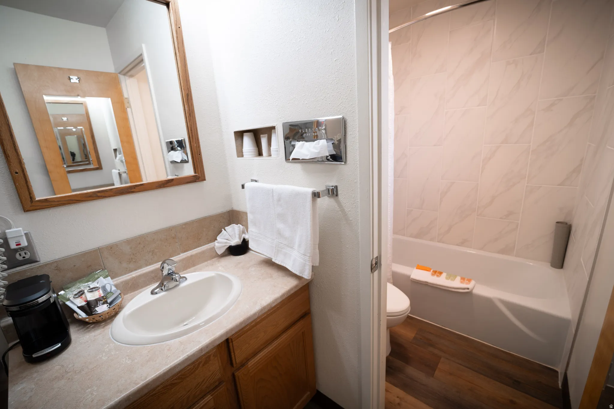 Full bathroom with shower / bathtub combination with curtain, dark wood-style flooring, and vanity