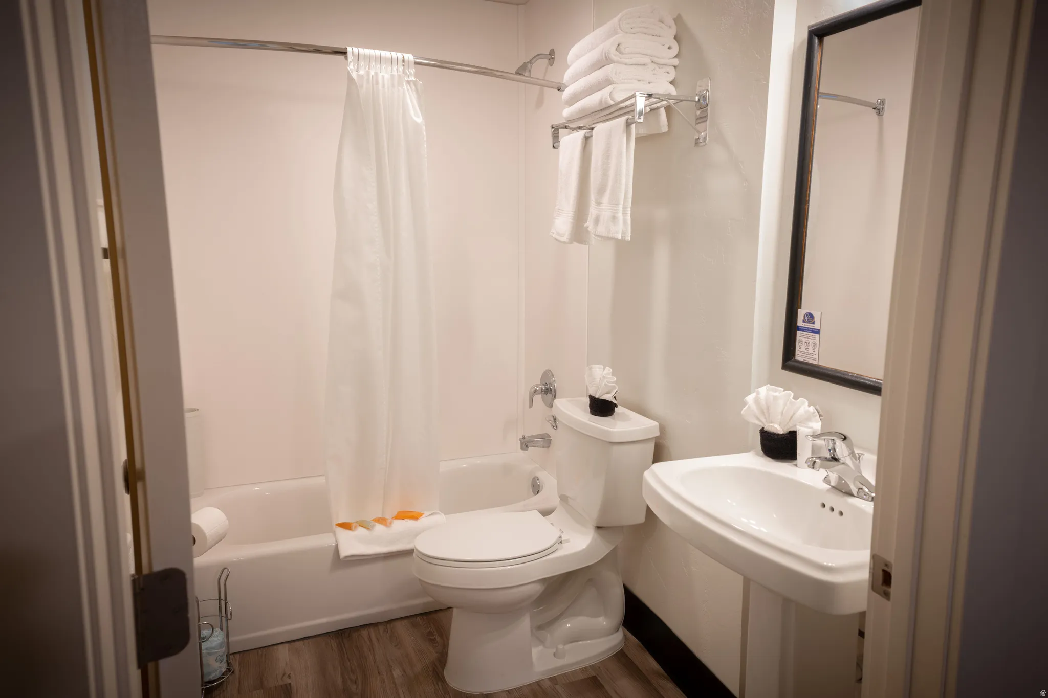 Full bath with shower / tub combo and dark wood-type flooring