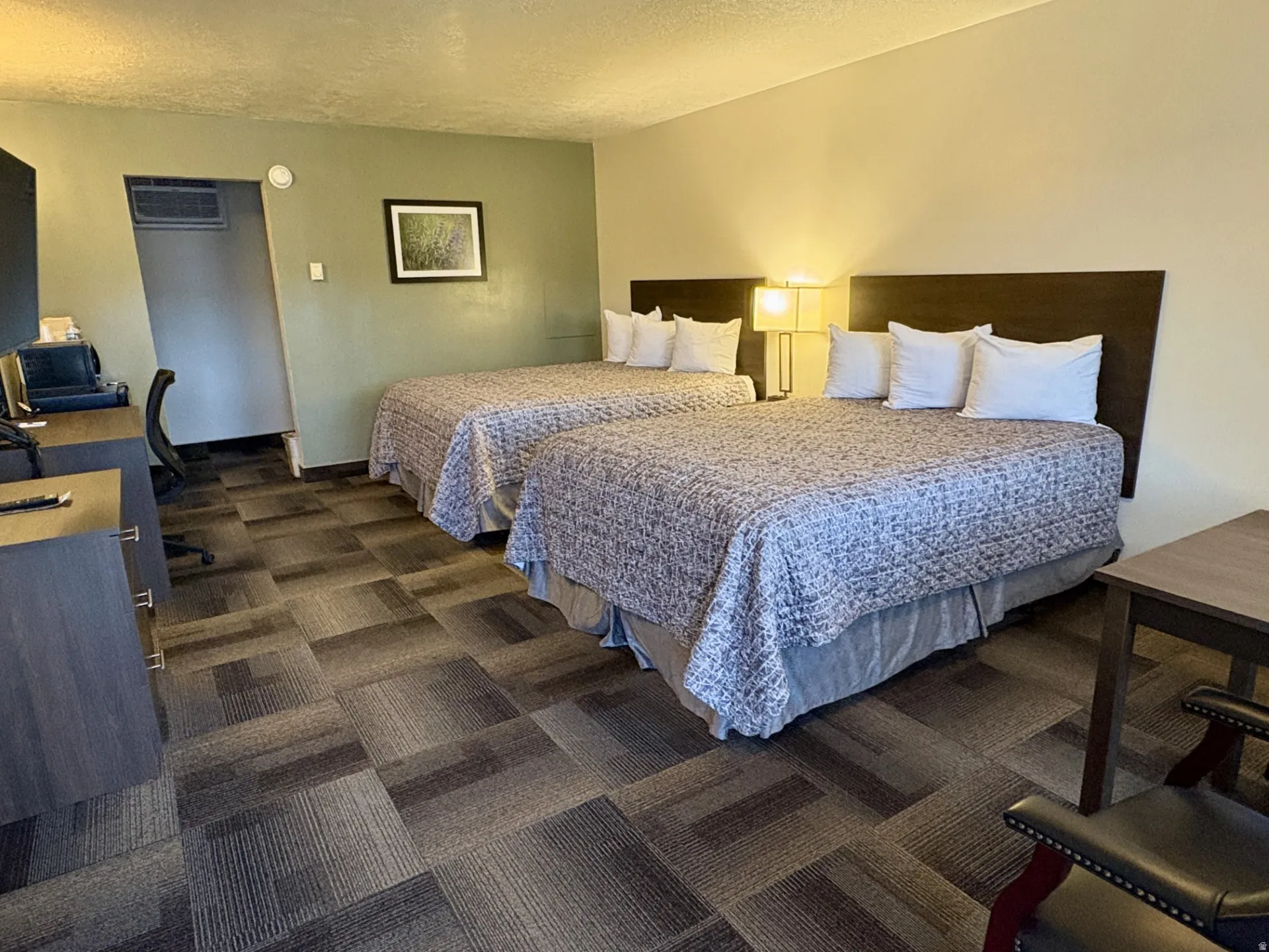 Bedroom featuring a desk, dark carpet, and a textured ceiling