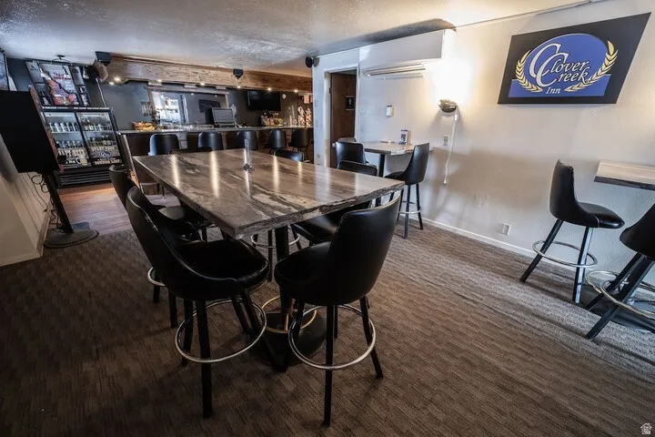 Dining room with a textured ceiling and dark carpet