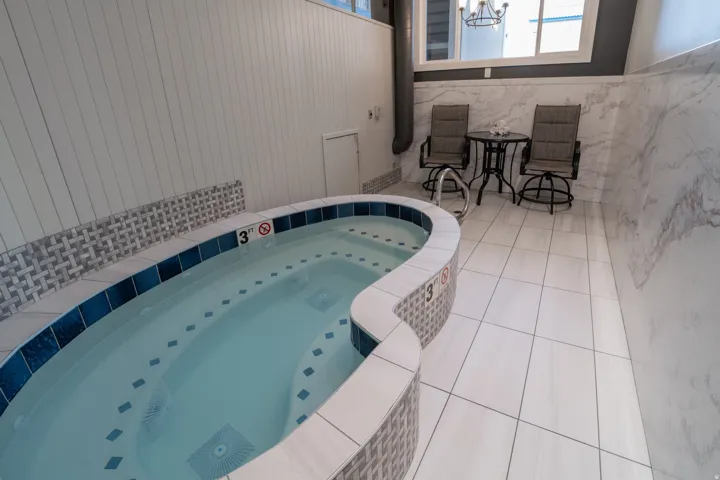 View of pool featuring a jacuzzi and patio surround