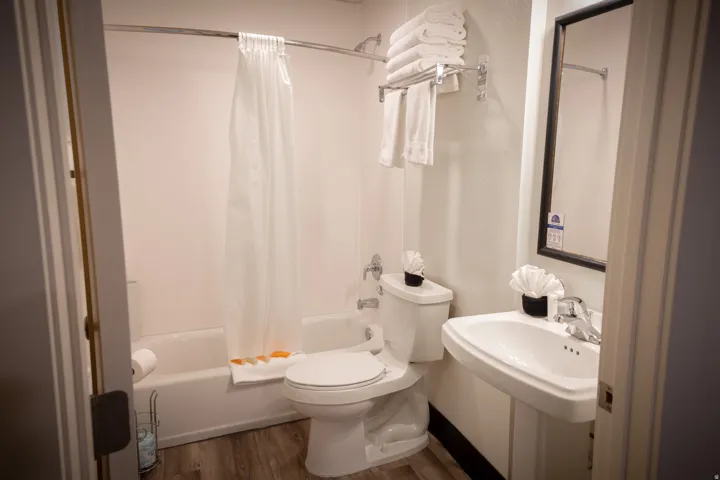 Full bath with shower / tub combo and dark wood-type flooring