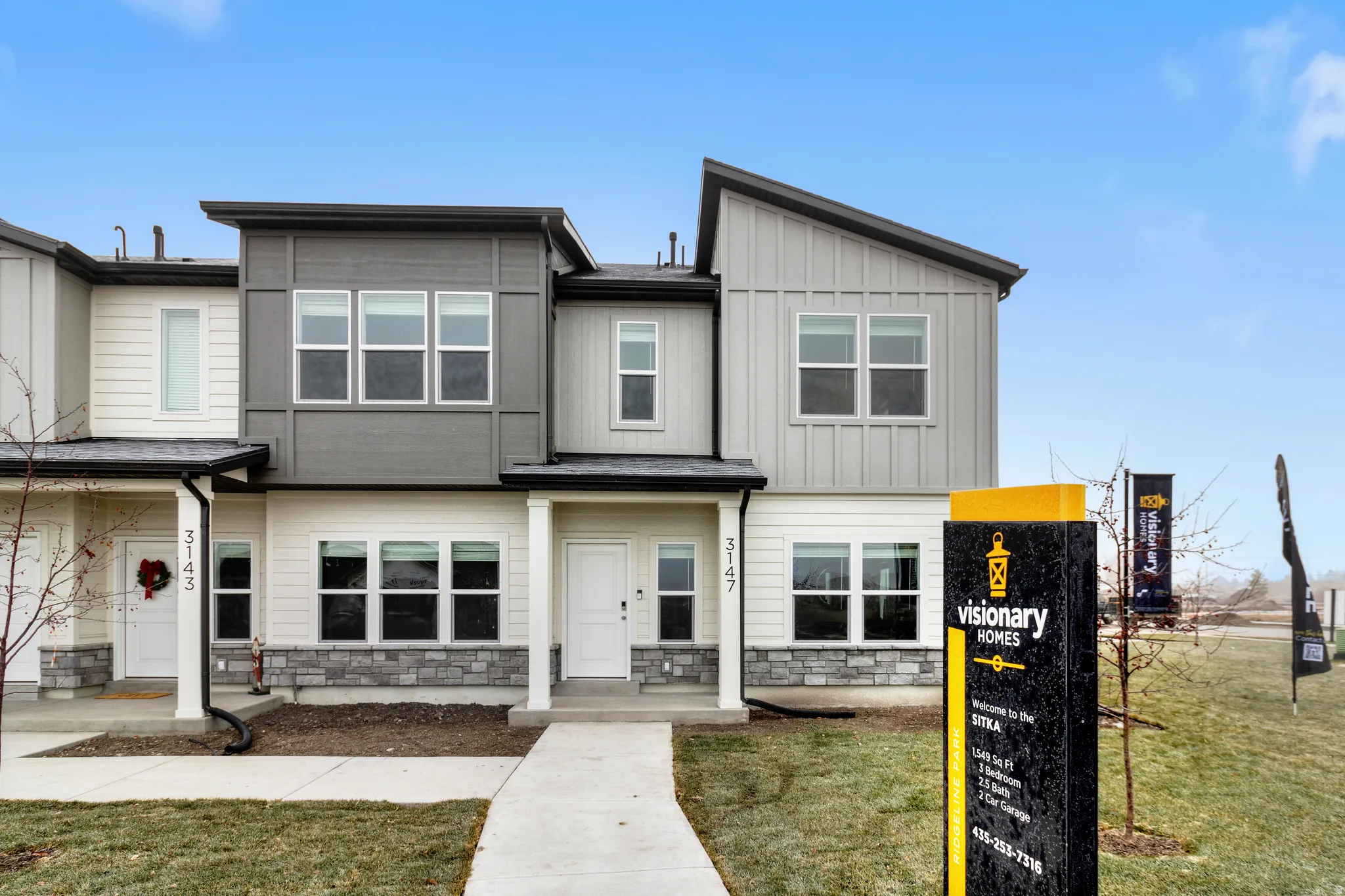 View of front of house with stone siding, board and batten siding, and a front yard