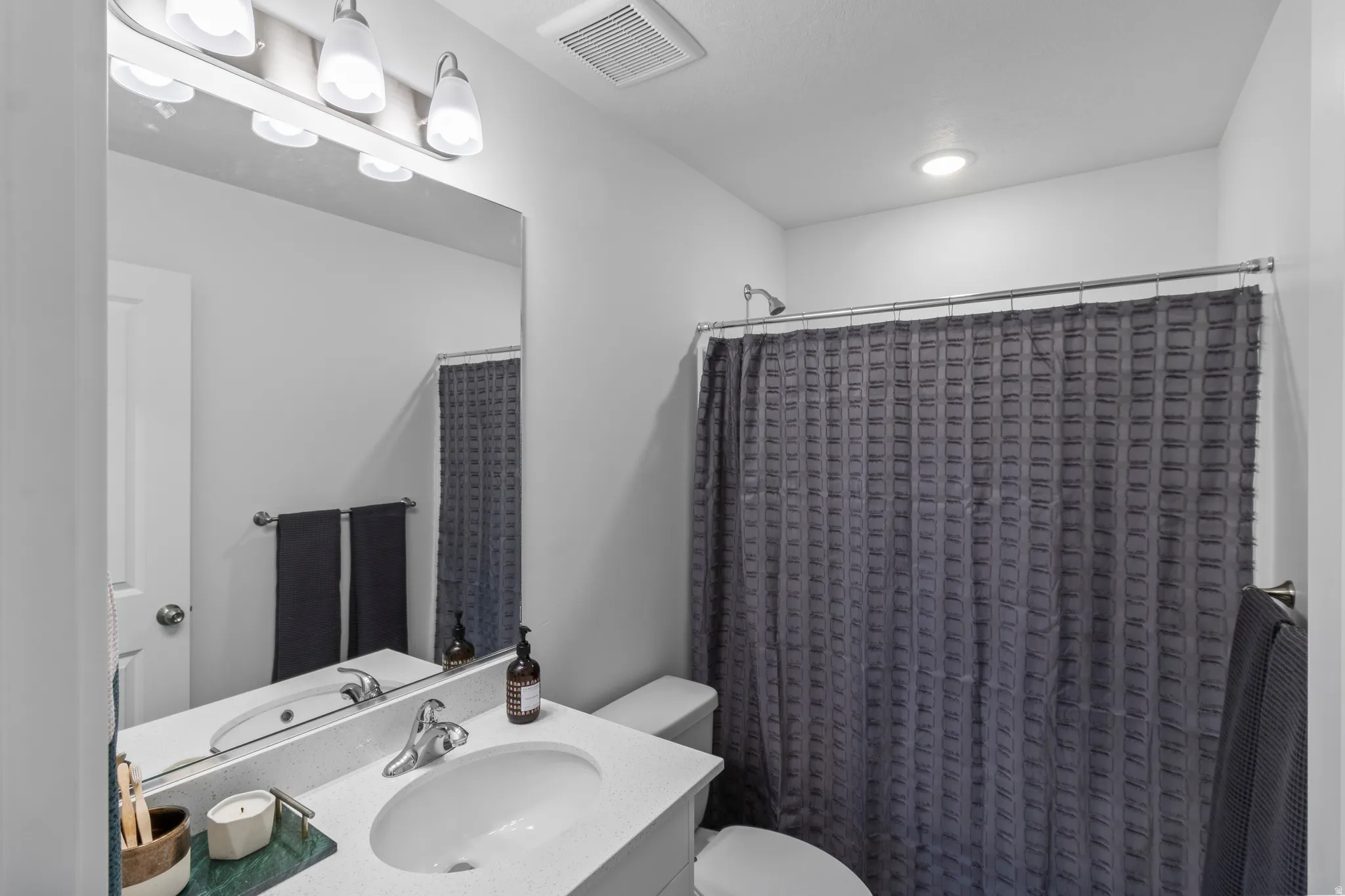 Full bathroom with vanity and a shower with shower curtain