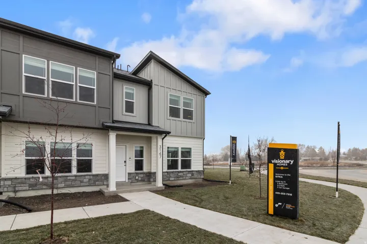 View of front of house with stone siding, a front yard, and board and batten siding