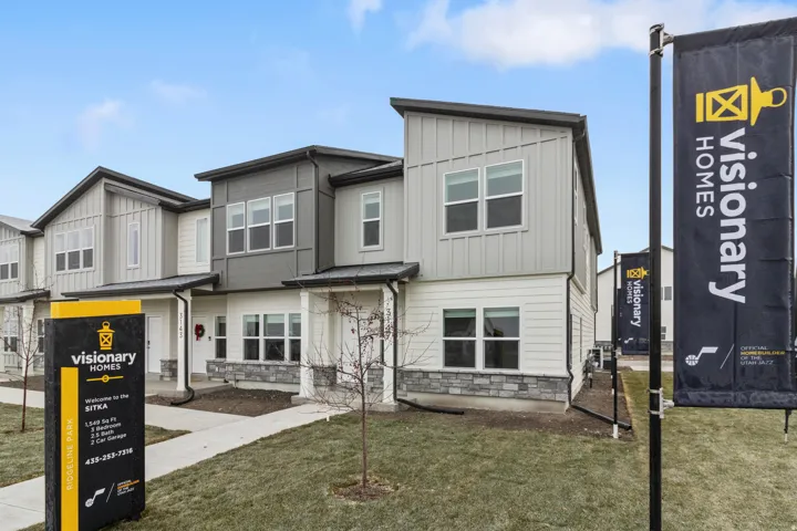 View of front of property with board and batten siding, stone siding, and a front lawn
