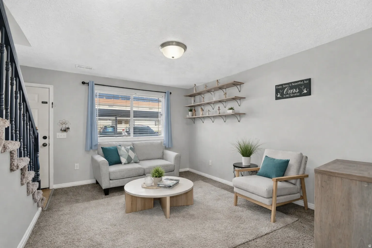 Virtually Staged living area featuring a large window with blinds, recessed ceiling light fixture, and a built-in wall shelf system