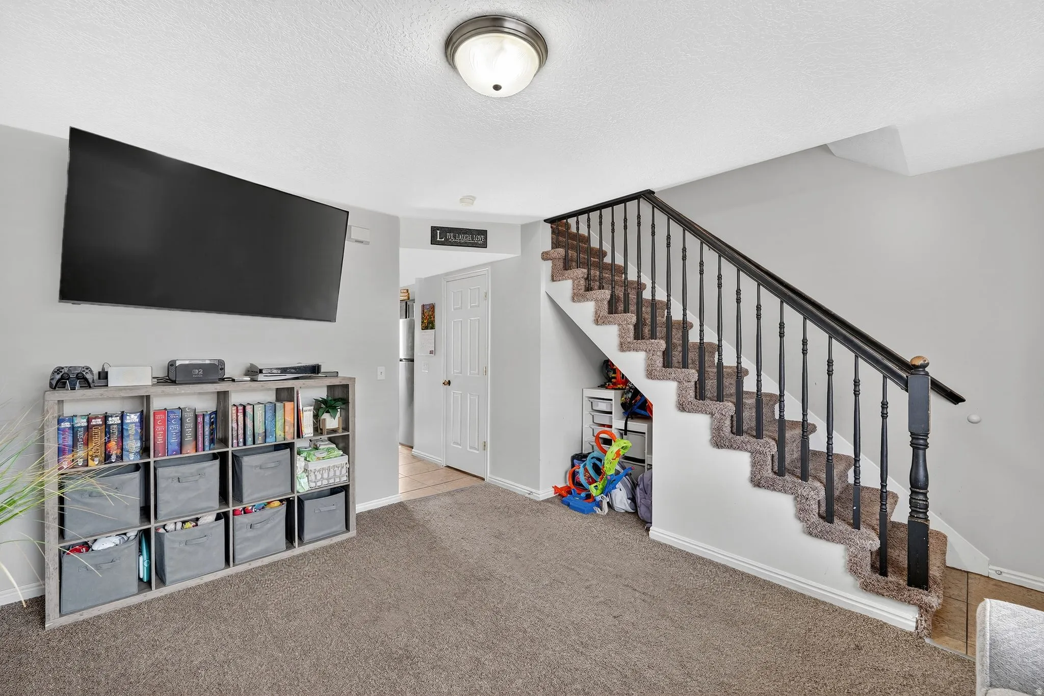 Rec room featuring carpet and a textured ceiling