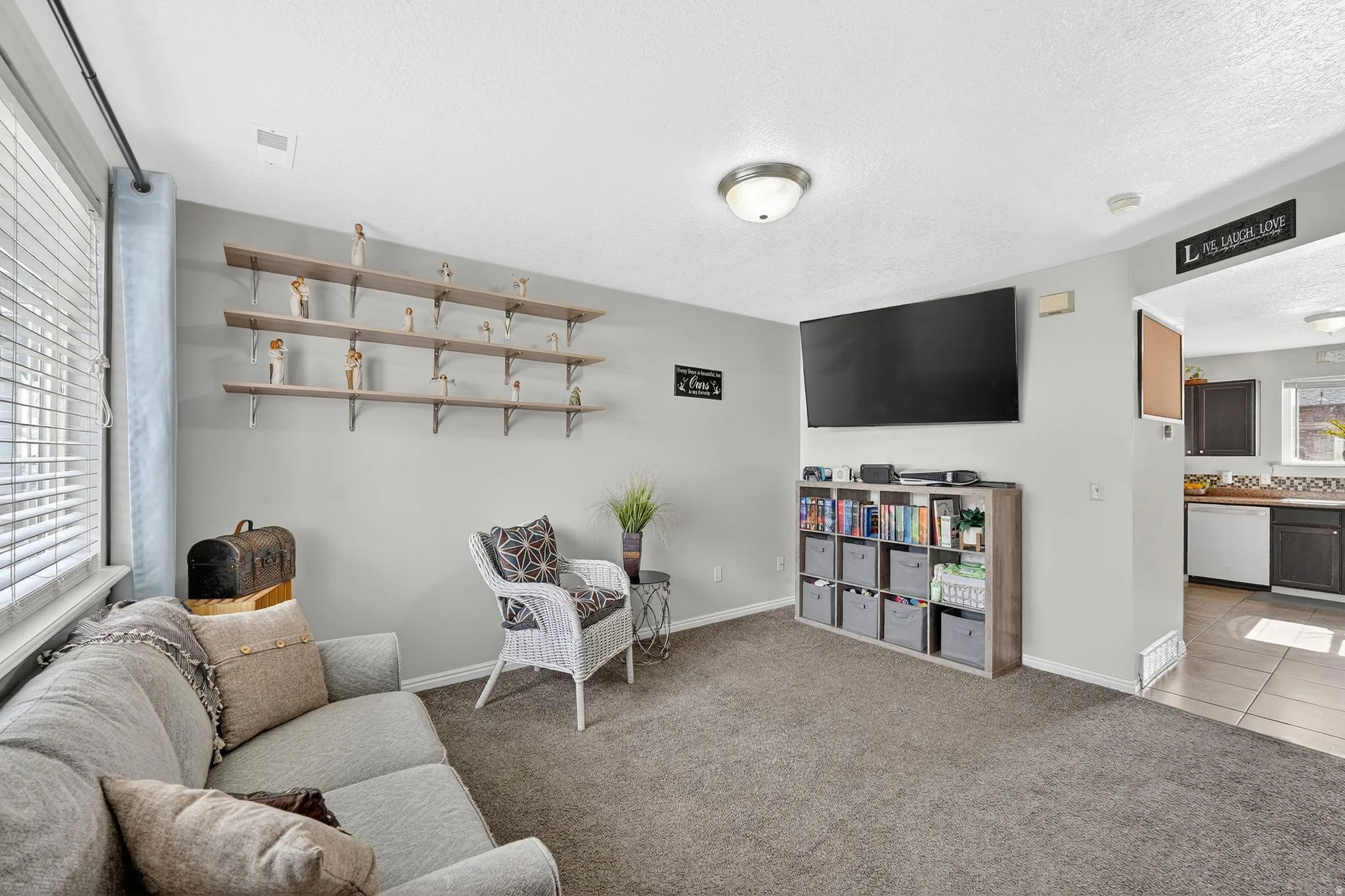 Living room featuring carpet floors, tile patterned floors, and a textured ceiling