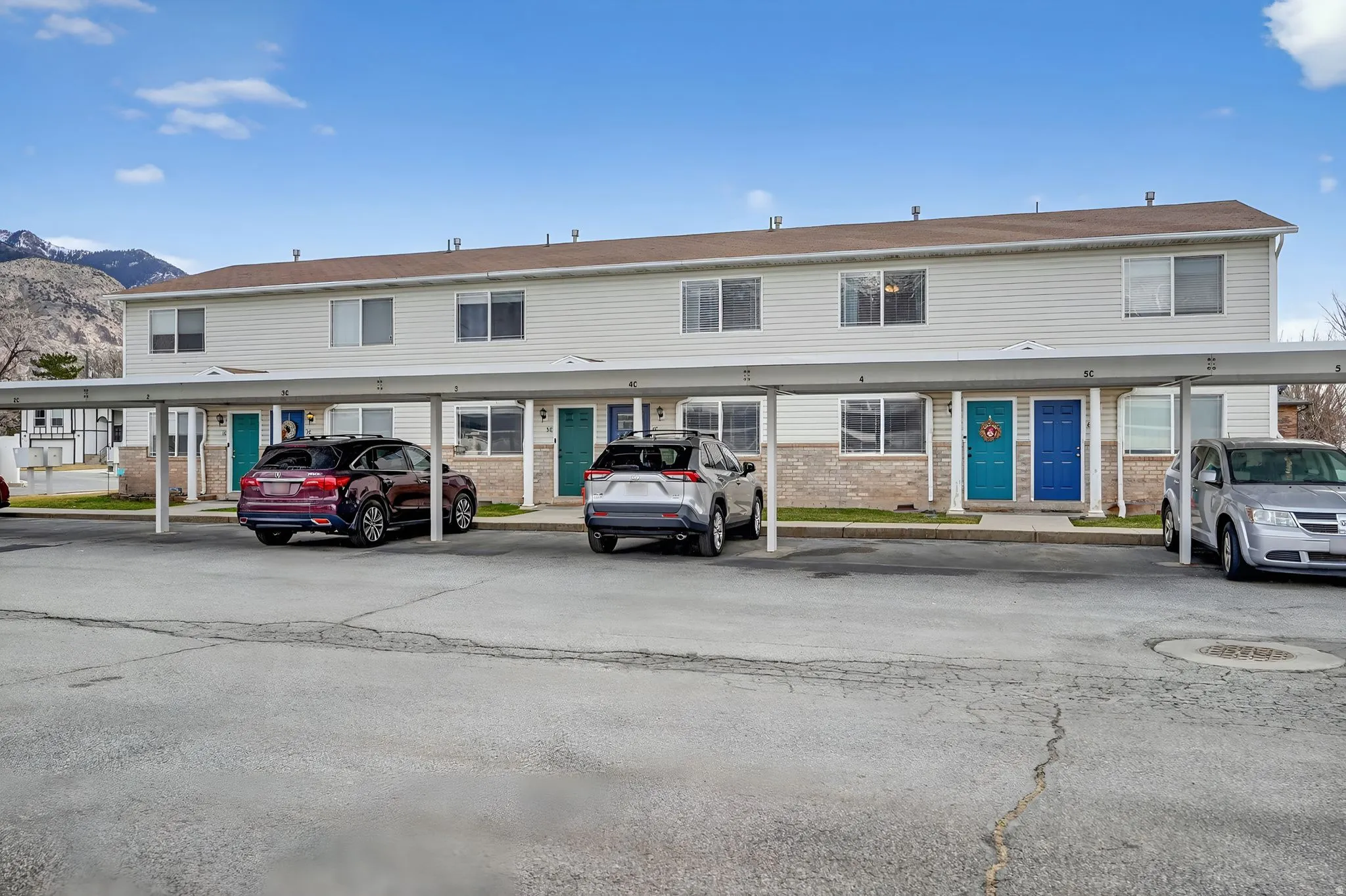 View of front of property with a mountain view, covered parking, and brick siding