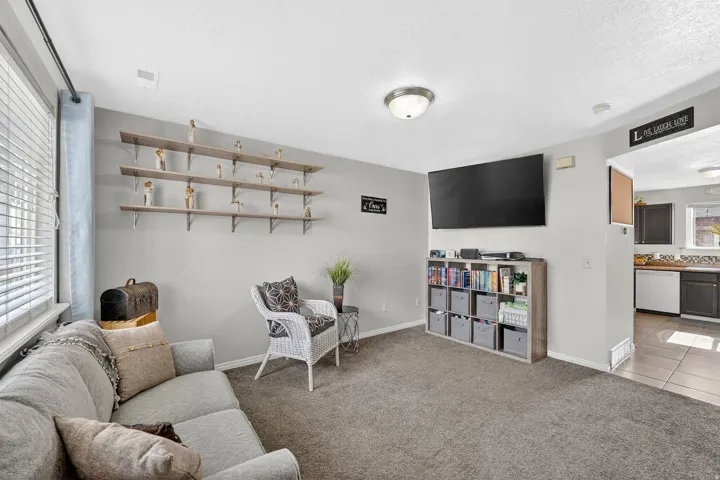 Living room featuring carpet floors, tile patterned floors, and a textured ceiling