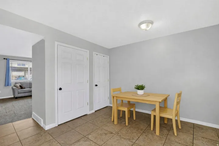 Dining area featuring tiled flooring and two paneled doors with black hardware