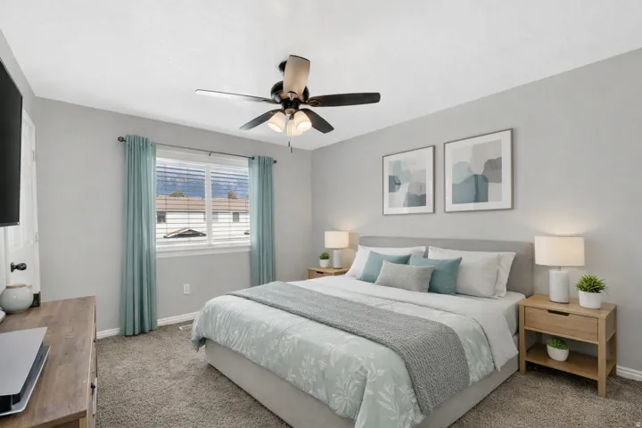 Virtually Staged bedroom featuring a ceiling fan with integrated lighting, a window with horizontal blinds, and light gray walls