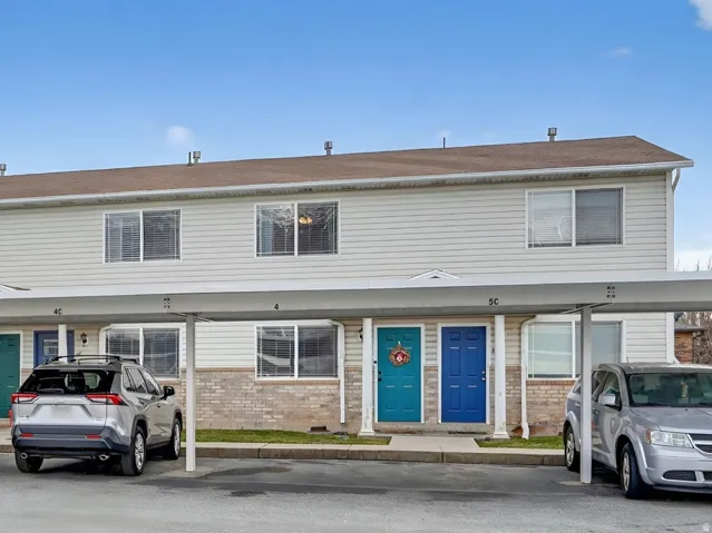 View of front of property with a mountain view, covered parking, and brick siding