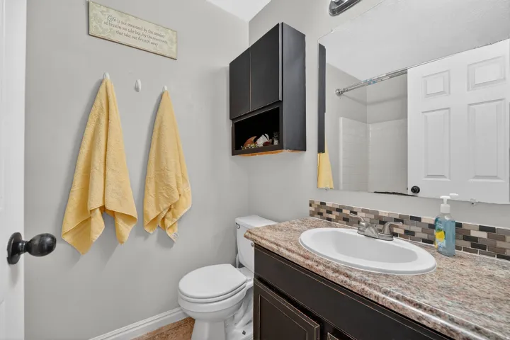 Bathroom with vanity, backsplash, and a shower