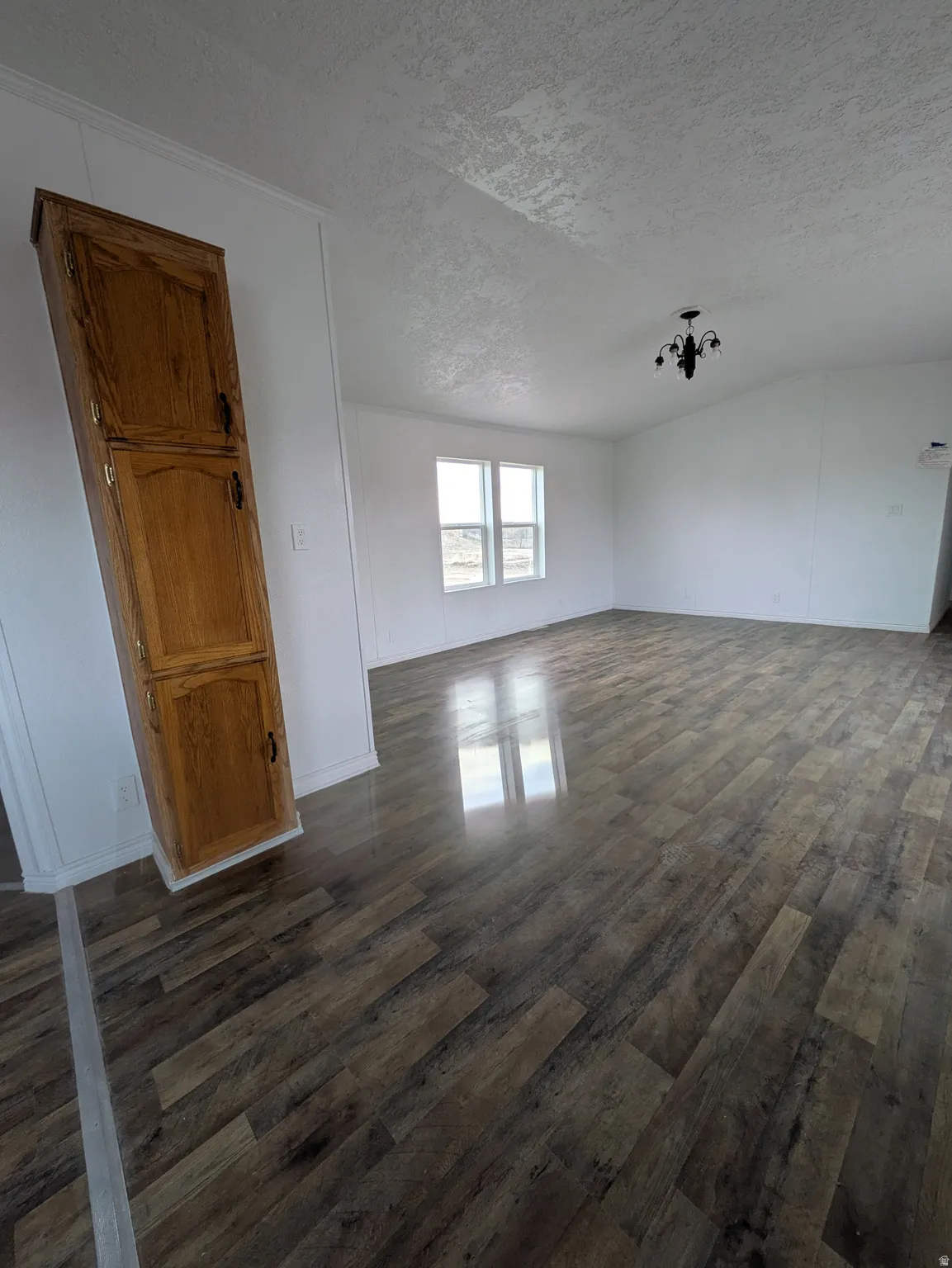 Unfurnished room featuring dark wood finished floors and a textured ceiling