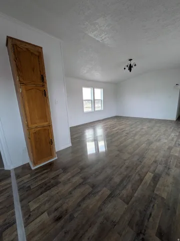 Unfurnished room featuring dark wood finished floors and a textured ceiling