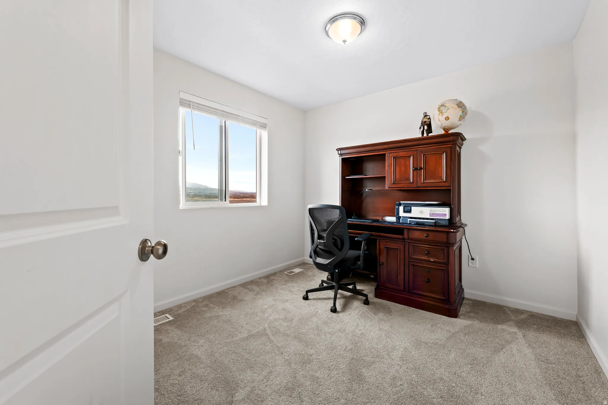 Office space featuring light colored carpet and baseboards
