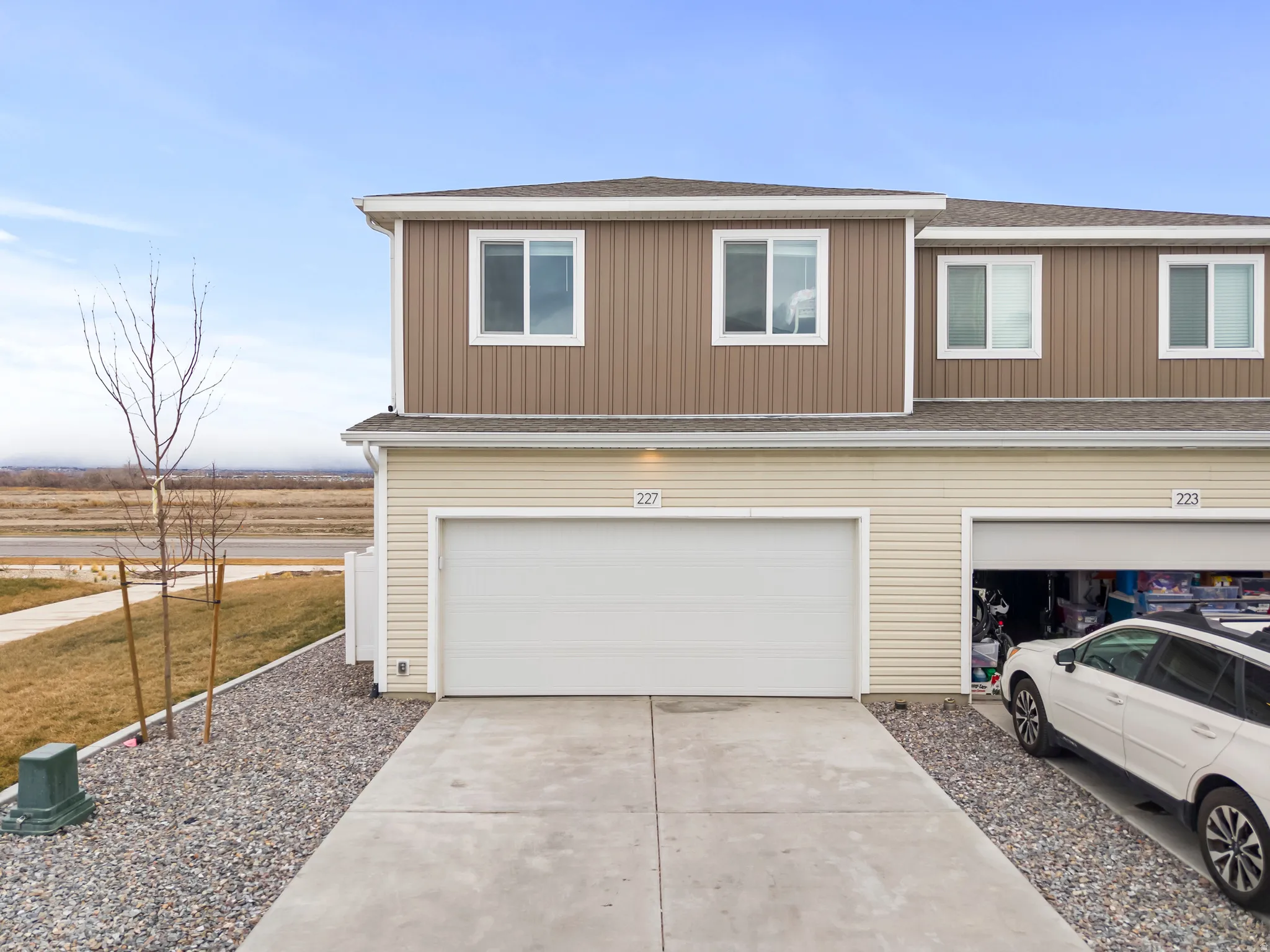 View of front of house with a shingled roof, concrete driveway, and an attached garage
