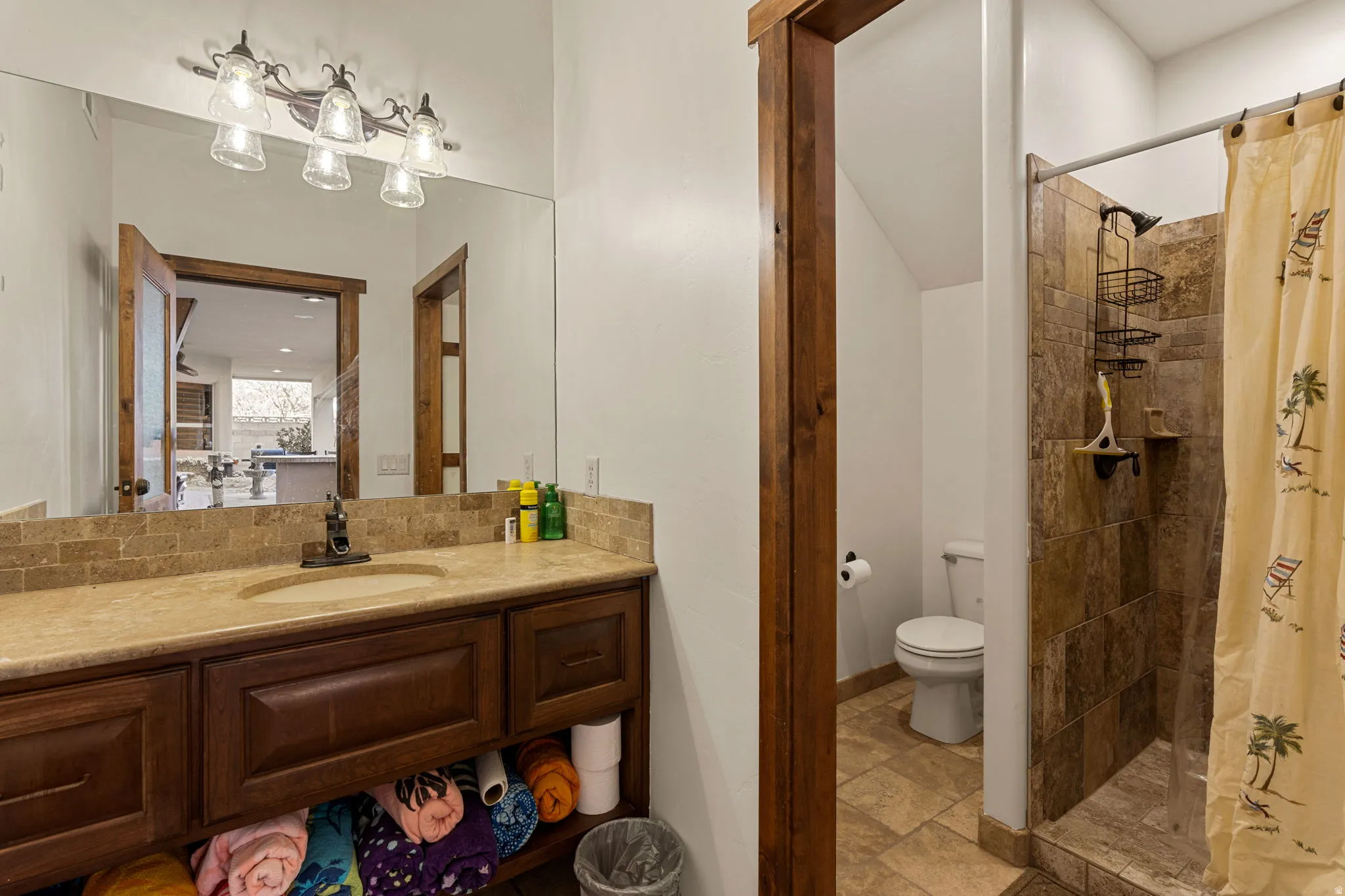 Outside Pool Bathroom featuring a stall shower, vanity, and light stone finish flooring