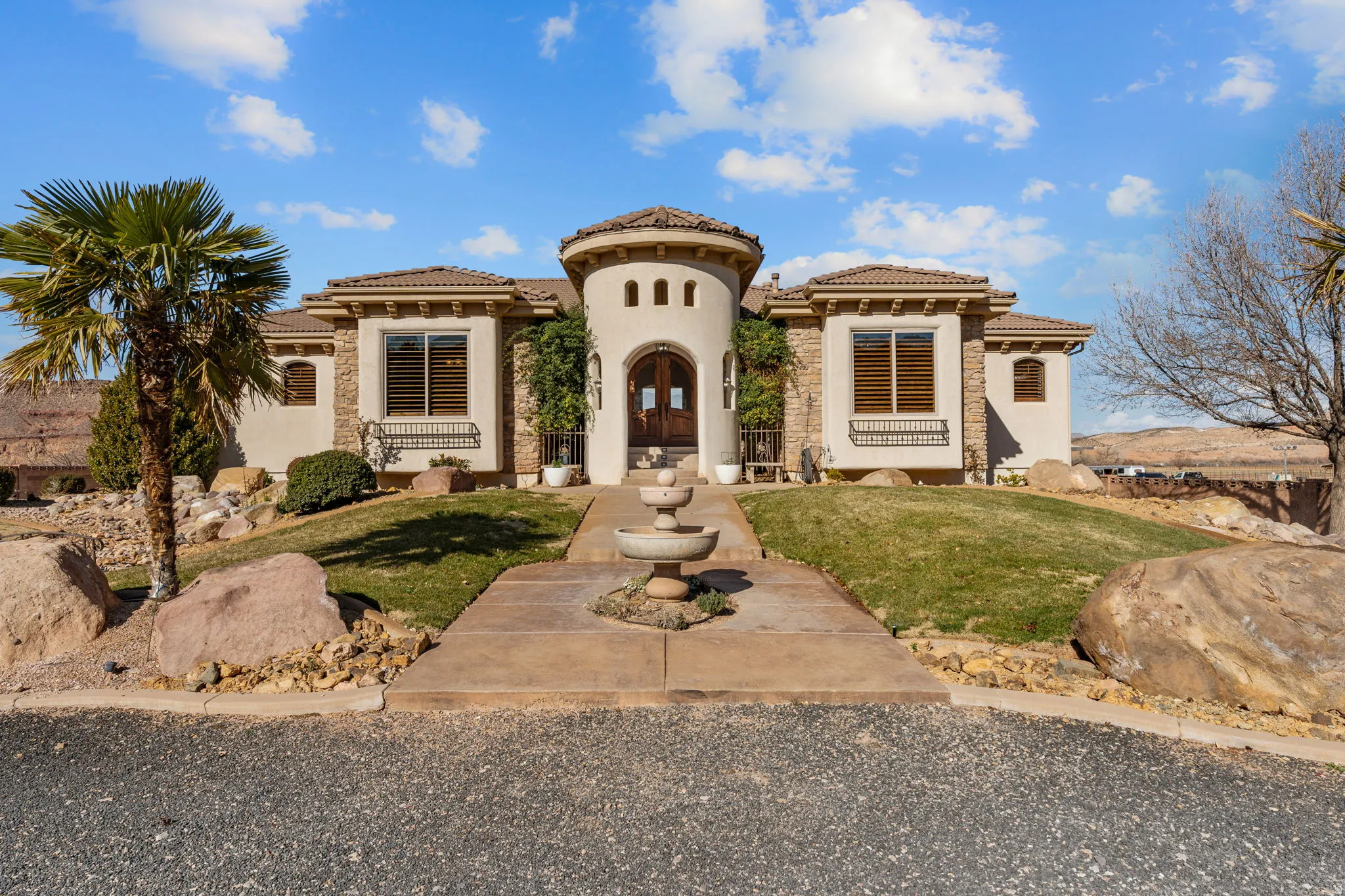 Mediterranean / spanish-style home with a front yard, stucco siding, and a tiled roof