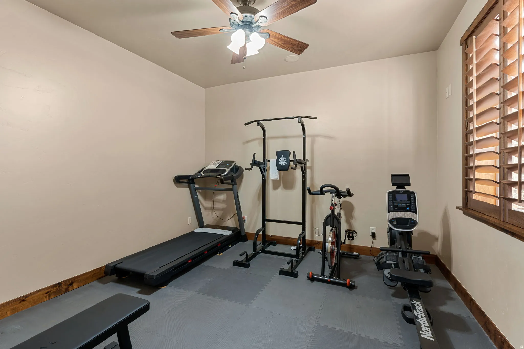 Exercise room with rubber floors and a ceiling fan