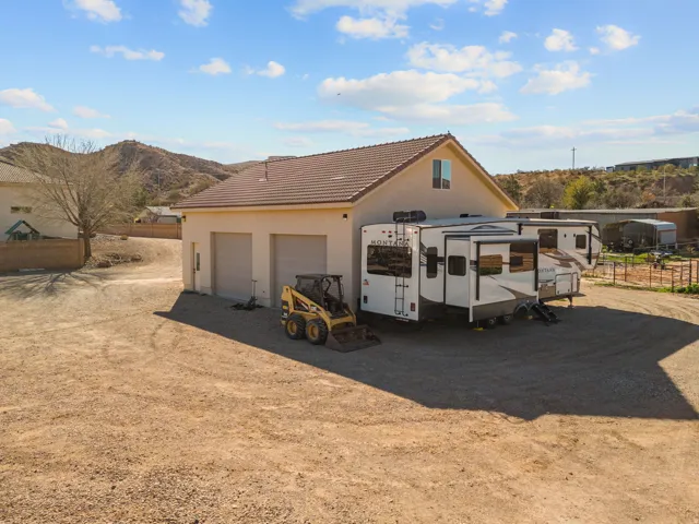 View of  RV/Boat Garage/Shop w/ a tile roof, stucco siding, an outbuilding, and driveway
