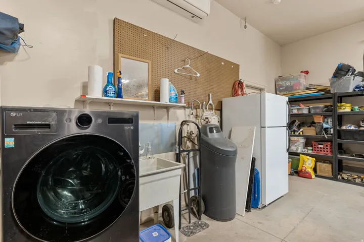 Laundry area featuring washer / clothes dryer, concrete flooring, and a mini split for heating / cooling