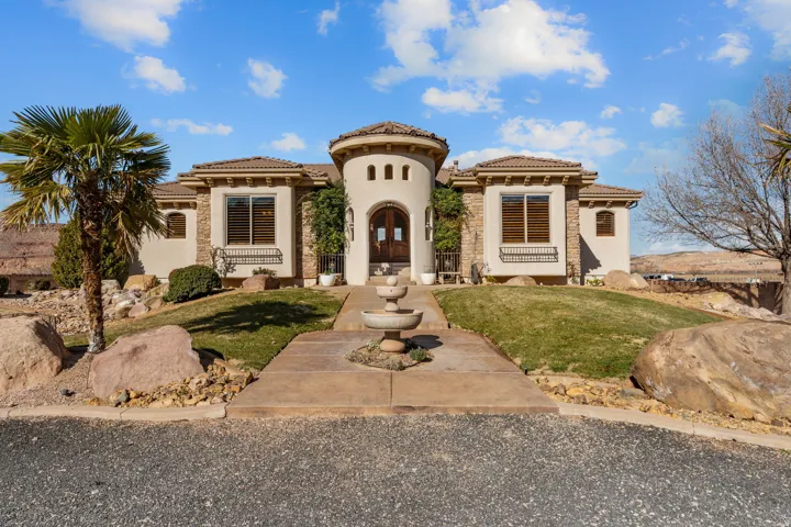 Mediterranean / spanish-style home with a front yard, stucco siding, and a tiled roof