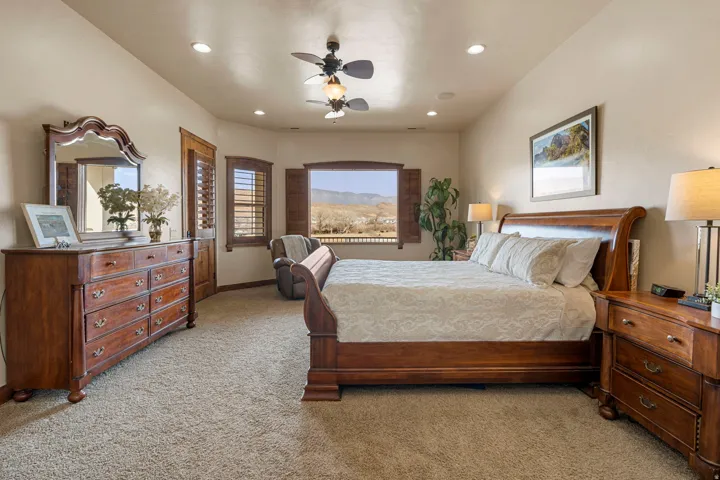 Primary Owner Suite featuring light carpet, ceiling fan, recessed lighting, and a mountain view