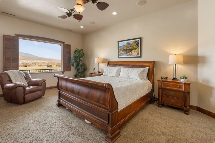 Primary Owner Suitefeaturing light colored carpet, a ceiling fan, a mountain view, and recessed lighting