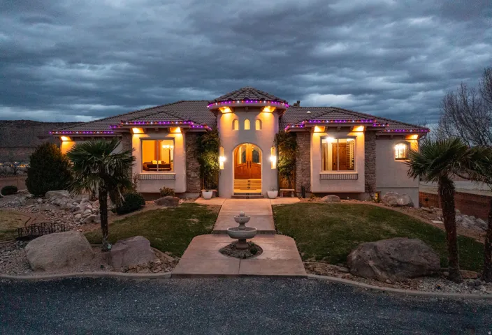 Mediterranean / spanish-style home featuring stucco siding, a front yard, and a tile roof