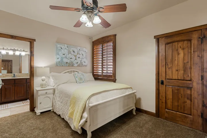 Bedroom #1 featuring carpet floors, connected bathroom, and ceiling fan