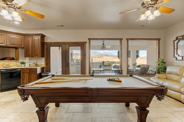 Rec room with a ceiling fan, stone tile floors, pool table, french doors, and a mountain view