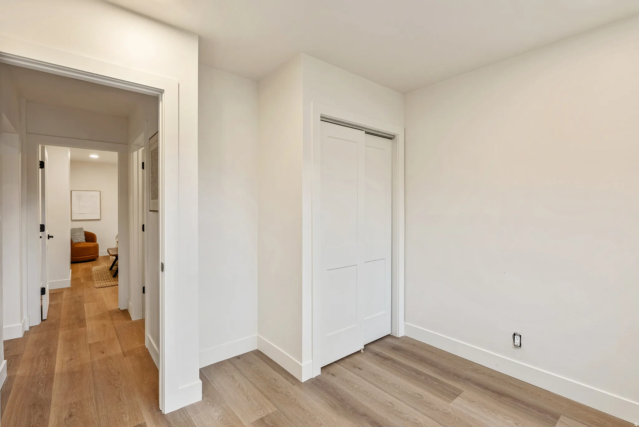 Hall with light wood-type flooring and baseboards