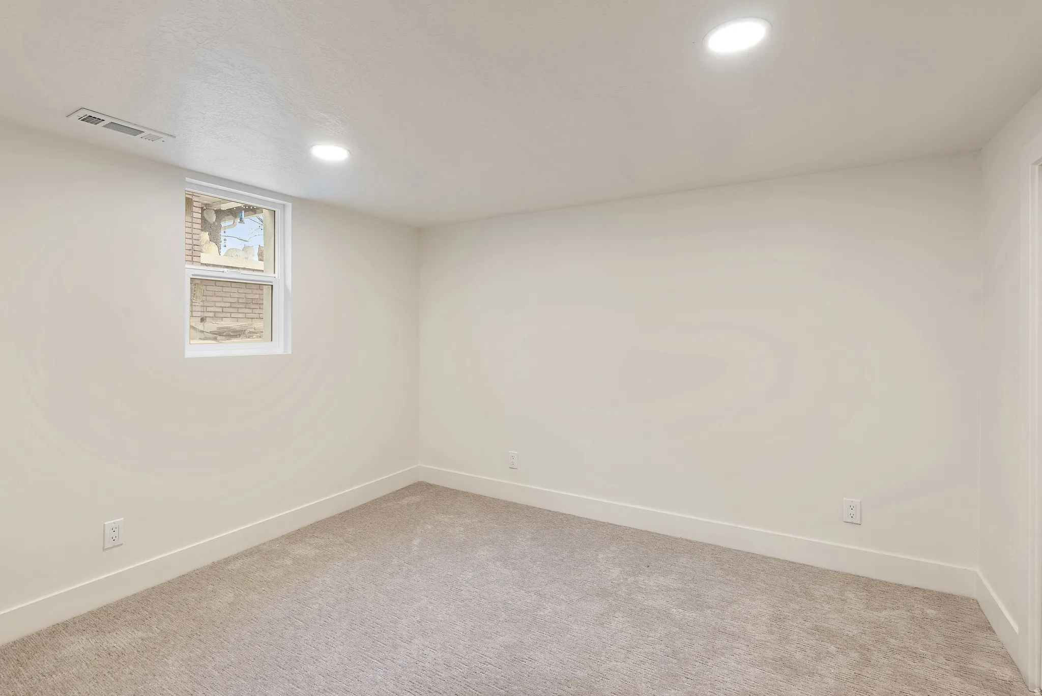 Unfurnished room with light colored carpet and recessed lighting