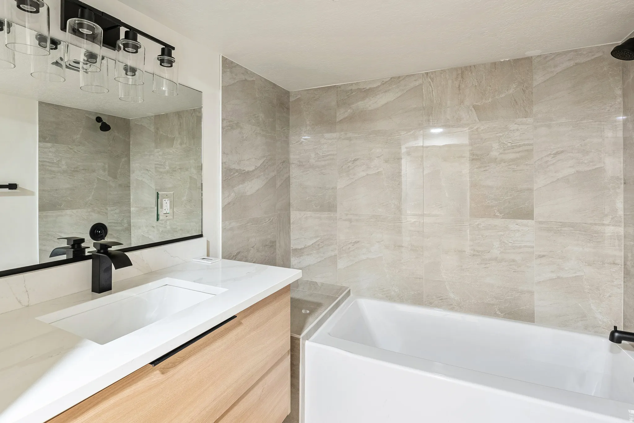 Full bath featuring vanity, bathtub / shower combination, and tile walls