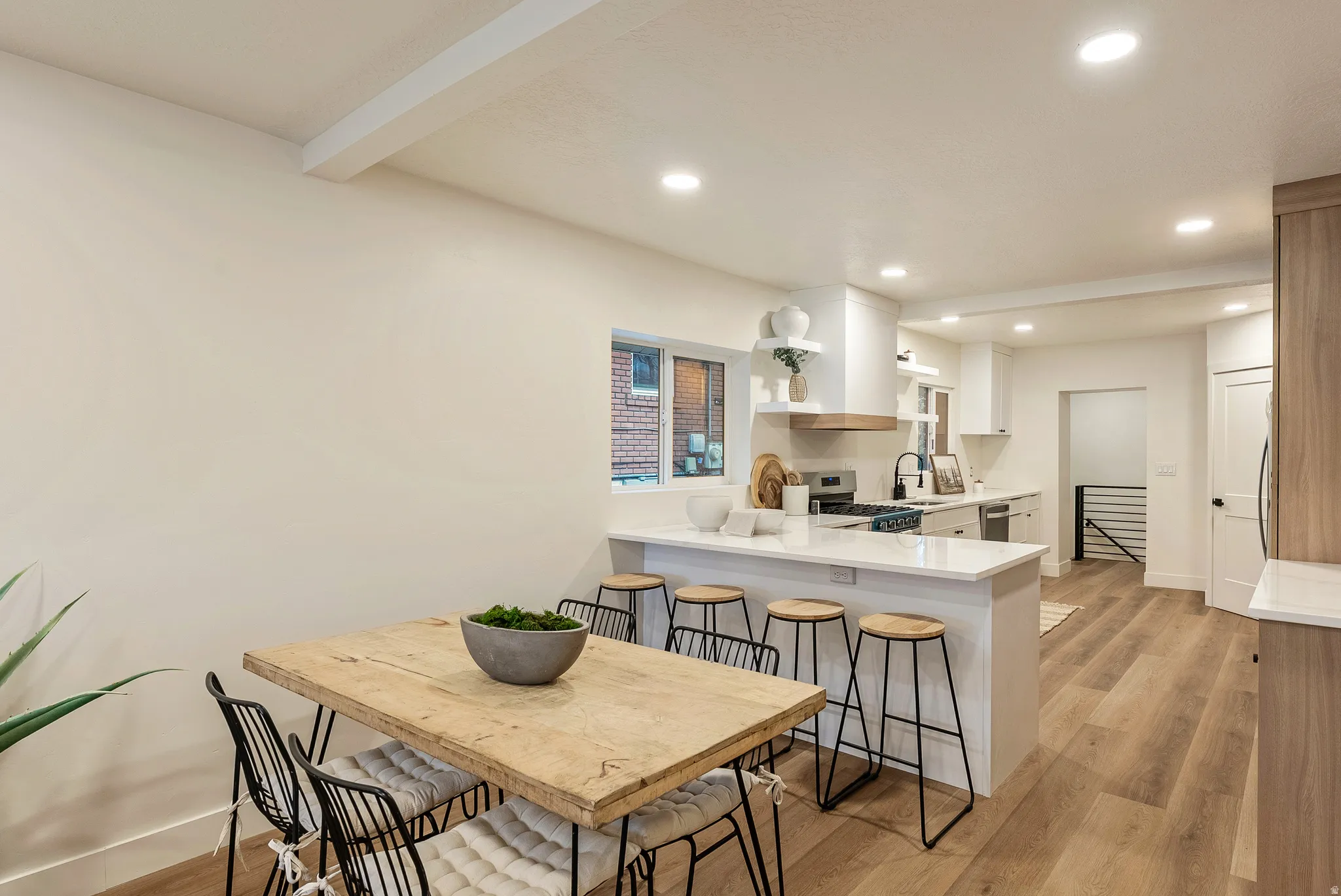 Dining space featuring light wood-style floors, recessed lighting, and beam ceiling