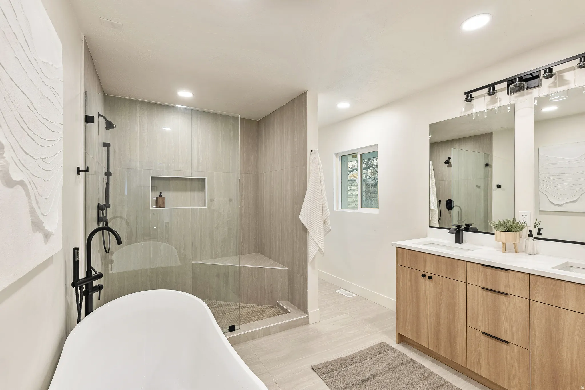 Full bathroom featuring a walk in shower, double vanity, a freestanding bath, and recessed lighting