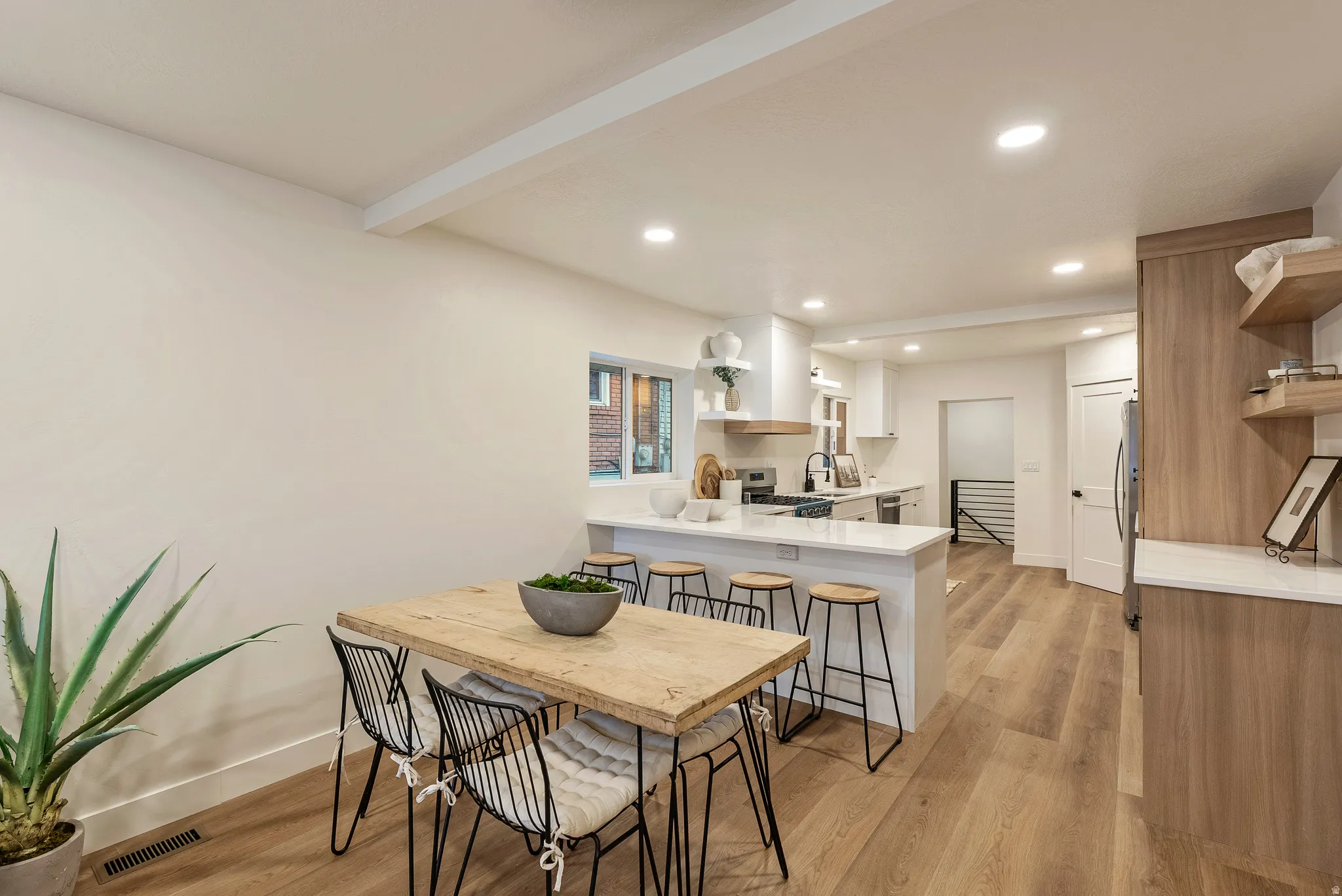 Dining space featuring light wood-style floors, recessed lighting, and beam ceiling
