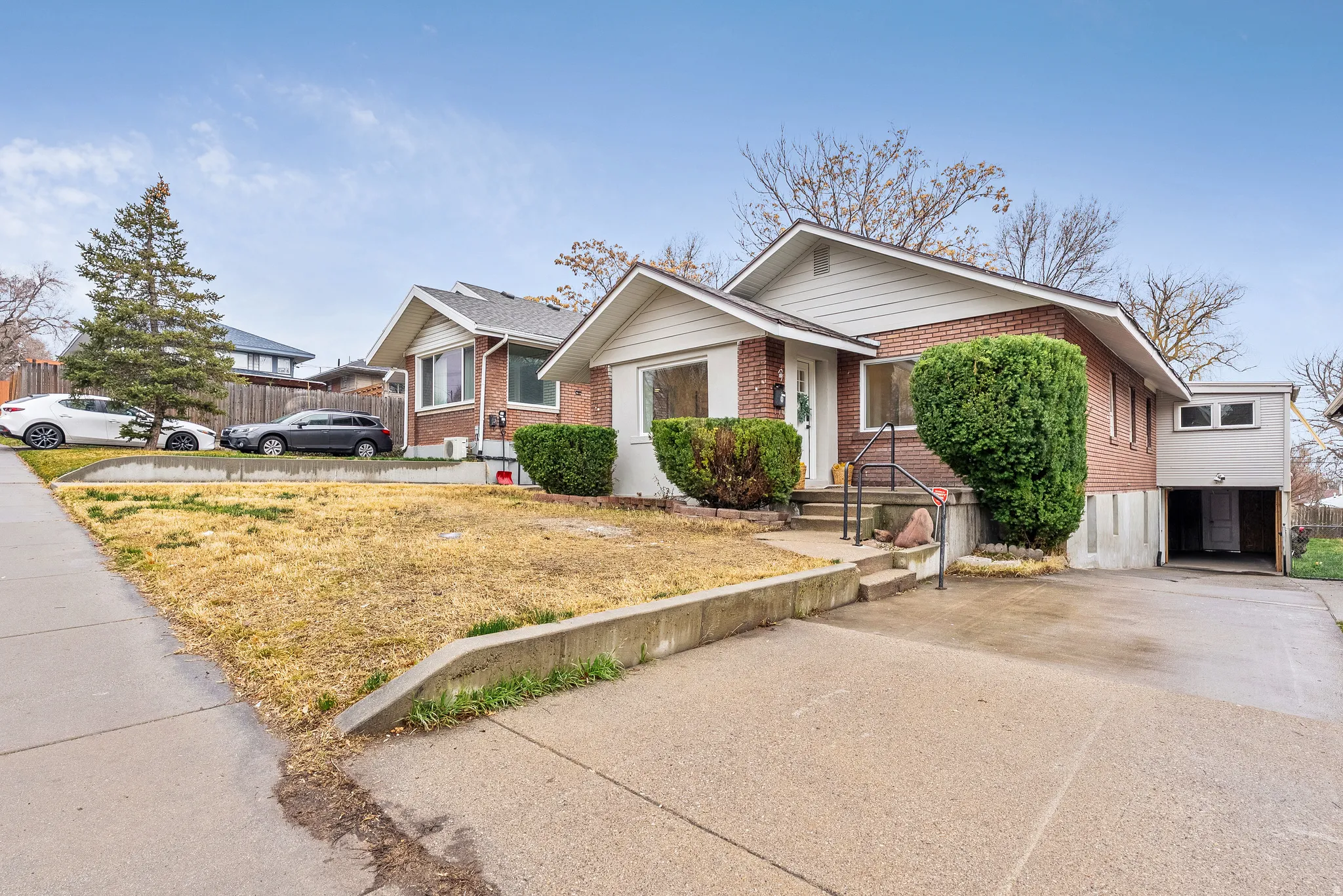 View of front of house featuring brick siding, a front lawn, and driveway