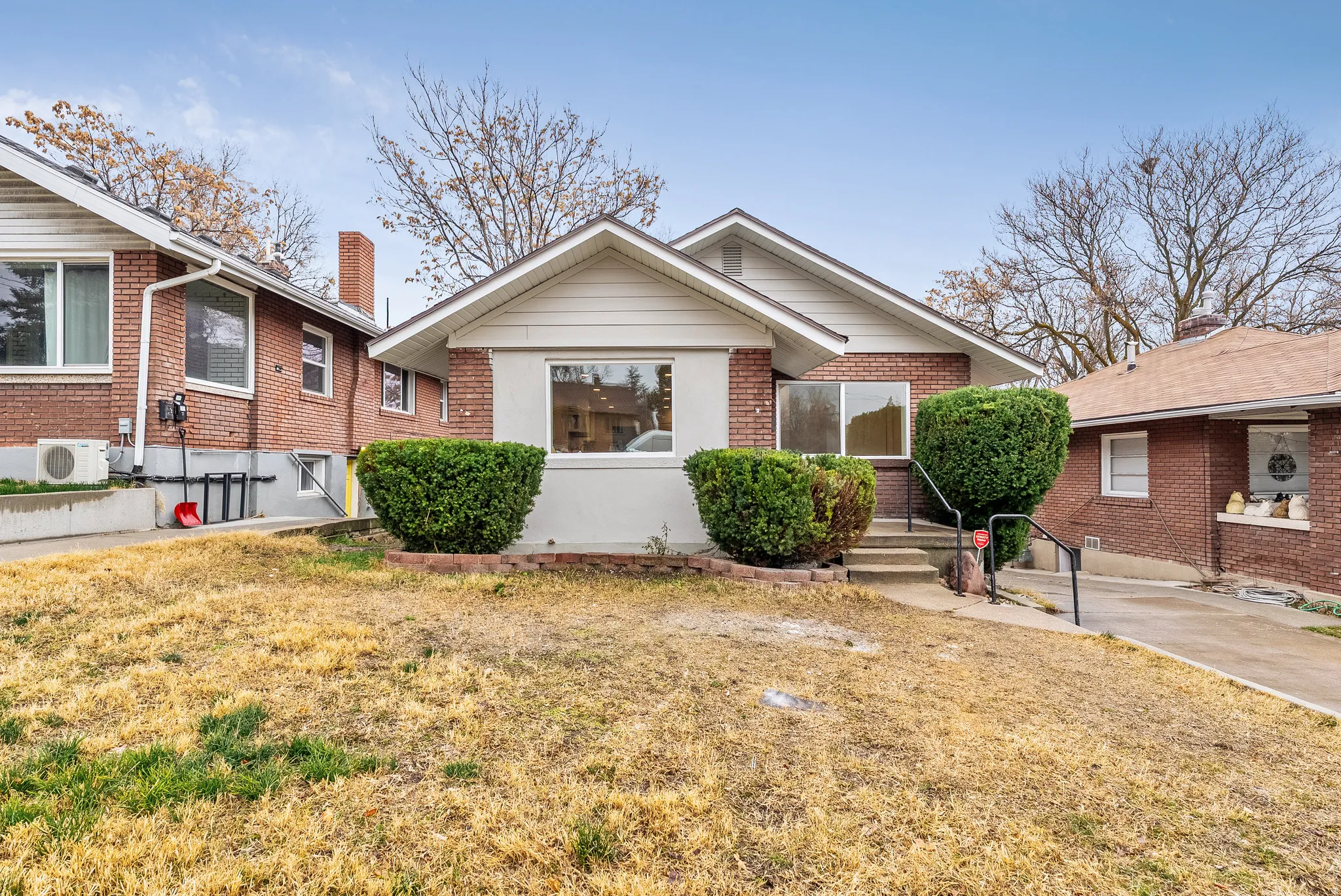 View of front of property featuring brick siding, a chimney, and a front yard