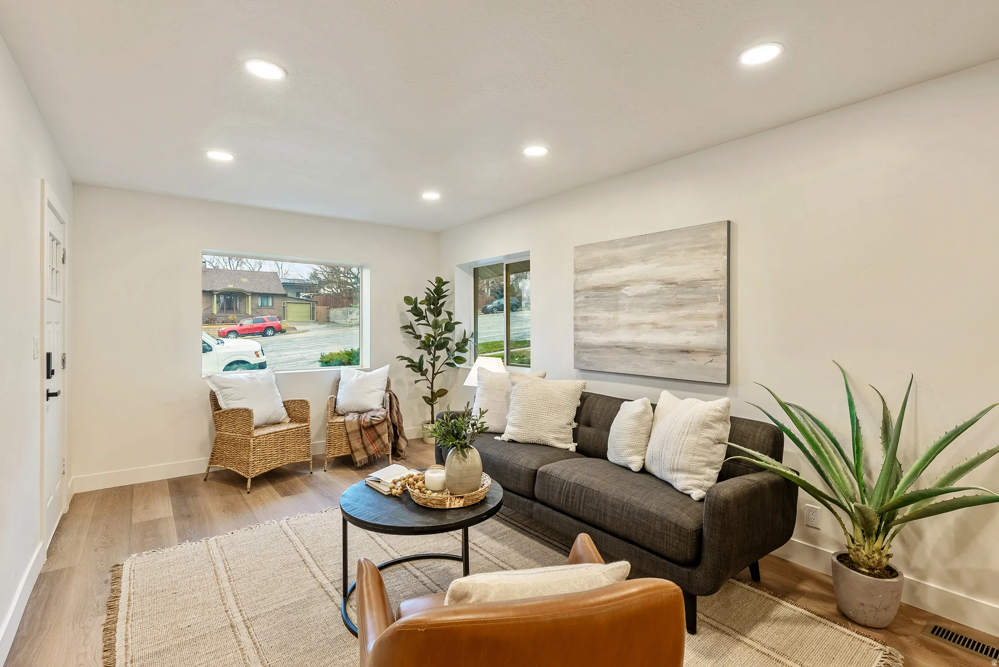 Living room with light wood-type flooring and recessed lighting