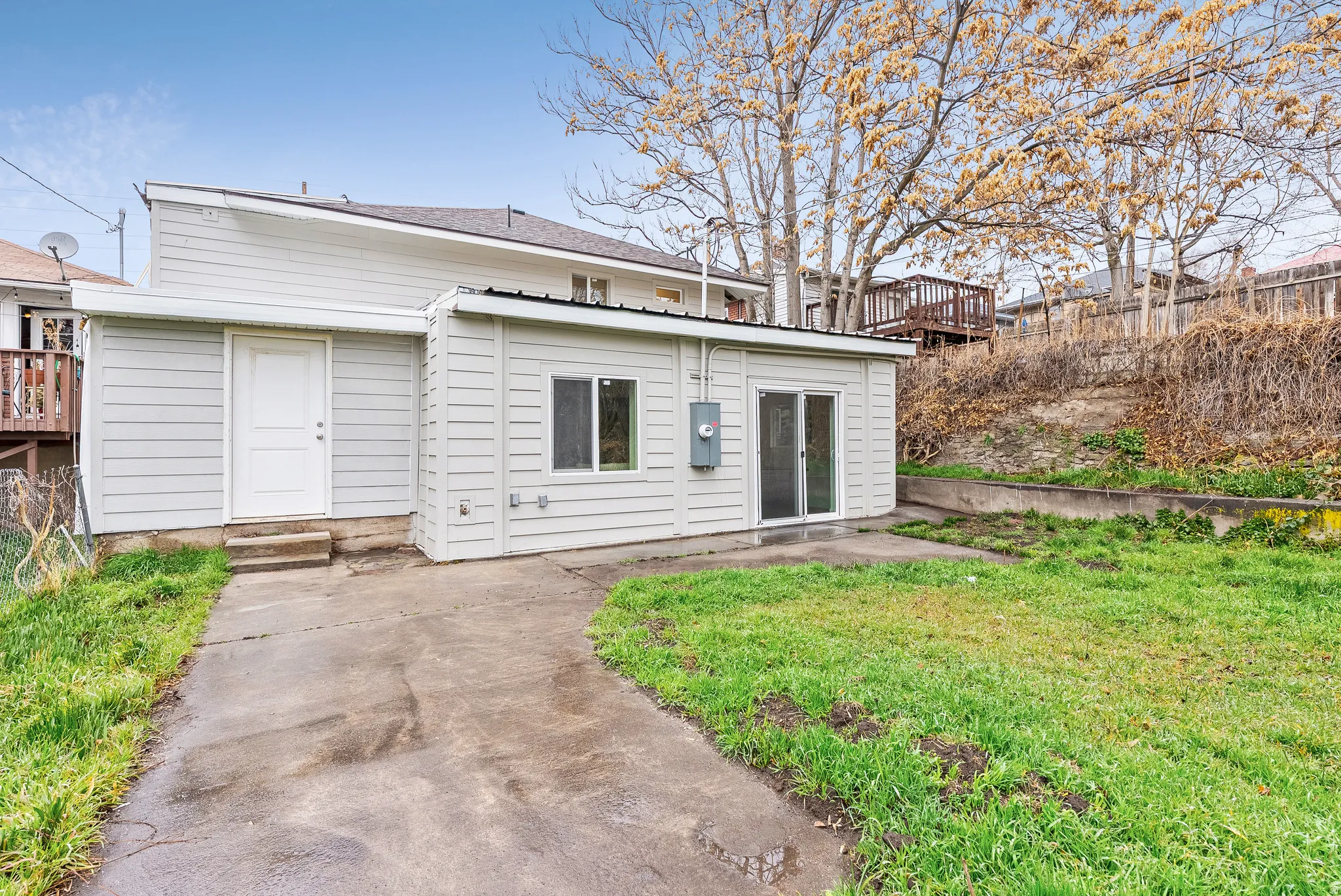 Rear view of house featuring a lawn and entry steps