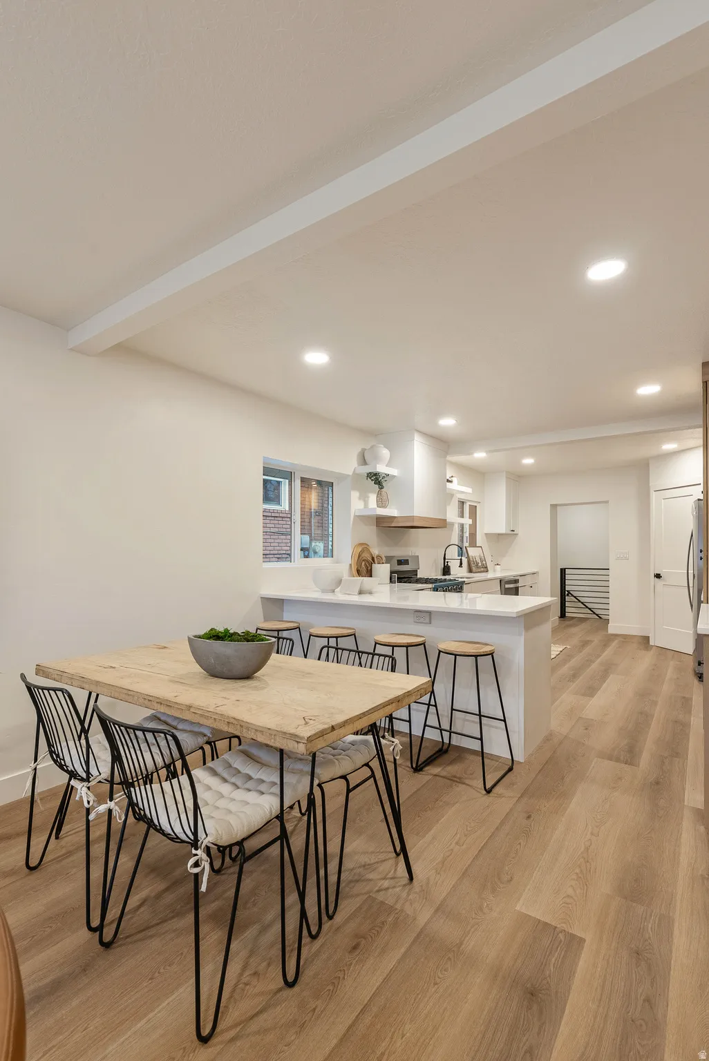 Dining room featuring light wood-style floors, recessed lighting, and beam ceiling